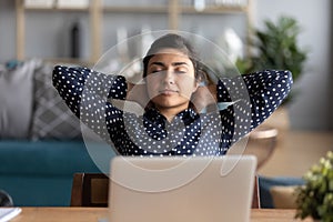Indian woman closed eyes relaxing sit stretching hands behind head