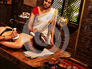 Indian woman doing massage with a bag of rice.