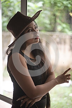 Indian woman in erotic mood standing in front of a glass wall wearing pink eye mask