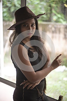 Indian woman in erotic mood standing in front of a glass wall wearing pink eye mask.