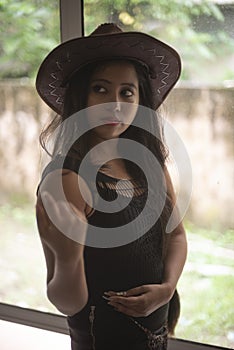 Indian woman in erotic mood standing in front of a glass wall wearing pink eye mask.