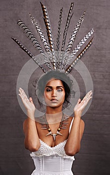 Indian woman, fashion and feathers with jewelry in studio on black background for heritage or culture. Portrait, female