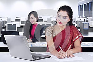 Indian woman and her partner working in office