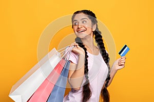 Indian woman holding credit card and shopping bags