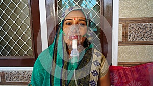 Woman suffering from Covid 19 disease. woman admitted in hospital and inhaling emergency oxygen with canula mask photo