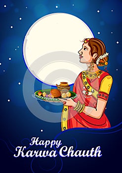 Indian woman looking moon through sieve during Karwa Chauth celebration photo