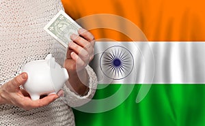 Indian woman with money bank on the background of India flag. Dotations, pension fund, poverty, wealth, retirement concept