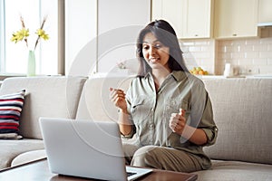 Indian woman online teacher talking by video call using laptop at home.