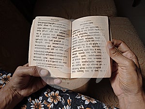 Indian woman reading bhagavad gita. Hindu religious book