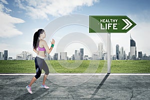 Indian woman runs toward healthy life text