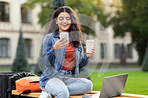 Indian woman student manages online studies via laptop and phone