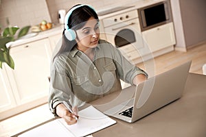 Indian woman student wear headphones watching online class seminar at home. photo