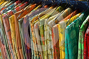 Indian woman traditional dress sarees in display, on hangers in a shop