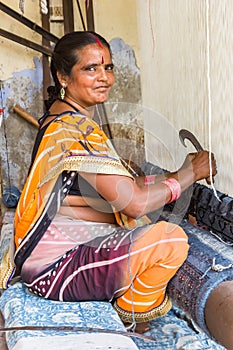 Indian woman weaving a hand made carpet in Jaipur