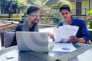 Indian young business people businessman freelancer working outdoors chaise lounge on the beach with laptop.two