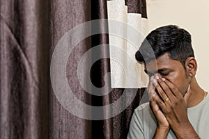 indian young man sad and covering his face with hand