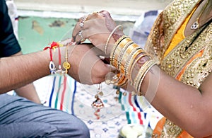 Indian young sister tying rakhi on brother`s wrist