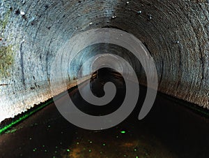 Indide dark round underground urban sewer tunnel