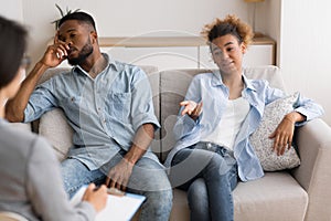 Indifferent Black Spouses Sitting On Sofa At Couples Therapist`s Office