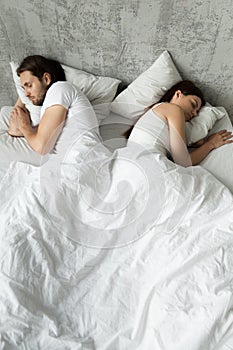 Indifferent couple sleep separately avoiding intimacy in bed