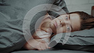 Indifferent Young Lady Looking At Camera Lying In Bed Indoor