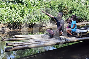 Indigenous Fijian man building a traditional Fijian bamboo boat