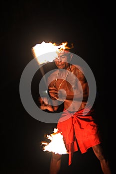 Indigenous Fijian man holds a torch during a fire dance