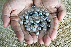 Indigenous Fijian woman holds Black lip oyster black pearls
