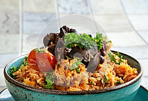 Indigenous Ghanaian, African-Caribian food Jollof Rice with tomato sause, regional spices, chicken meat and offal