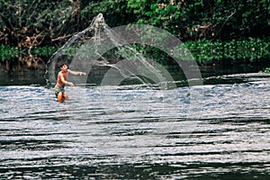 Indigenous man net fishing at Xingu River