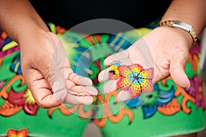 Indigenous Woman Beading Flower Coaster At Market Stall For Tourists