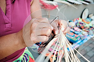 Indigenous Woman Weaving Coaster At Street Market Stall photo