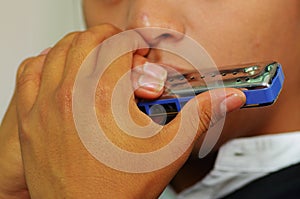 Indigenous young man playing the harmonica