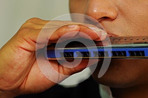 Indigenous young man playing the harmonica