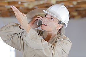 indignant construction female worker talking on mobile phone photo