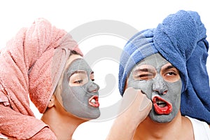An indignant girl beats a guy in the face , mask for skin man and woman, guy with a girl make a mask for the skin together, funny