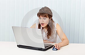 Indignant woman works in Internet with laptop