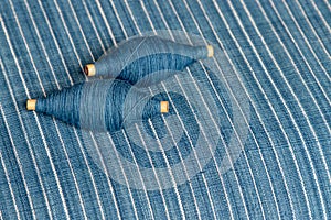 Indigo dyed yarn in reel and indigo dyed woven fabric background