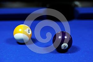 Indigo and yellow billiard balls on a blue billiard table.