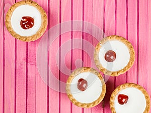 Individual Bakewell Tarts On A Pink Background