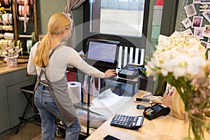 individual entrepreneur owner of a flower and gift shop at the workplace behind a cash register