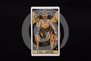 An individual major arcana tarot card isolated on black background. The Devil.