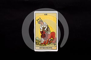 An individual major arcana tarot card isolated on black background. Strength.