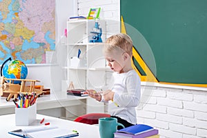 Individual teaching. Child near chalkboard in school classroom. Kids Science education concept.