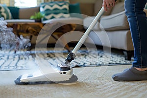 individual using a steam mop on a carpet with a glider attachment