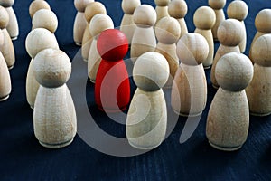 Individuality, personality and originality concept. Red wooden figure in crowd photo