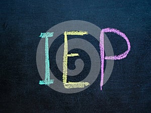 Individualized Education Program IEP written in chalk on blackboard.