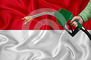 INDONESIA flag Close-up shot on waving background texture with Fuel pump nozzle in hand. The concept of design solutions. 3d