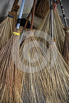 Indonesia Traditional Broomstick Made From Dried Palm Tree Leaves Lean on The Wall Pillar.