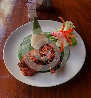 Indonesian Balinese spicy roasted duck with cone rice on banana